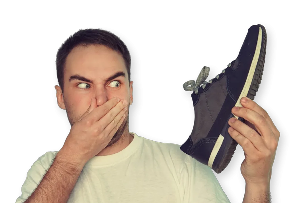 Man ruikt aan een sneaker bij stinkvoeten en terugkerende voetgeur